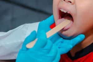 Child practicing myofunctional exercises with guidance from a pediatric dentist